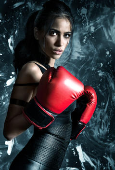 Young woman with boxing gloves in fitness dress.