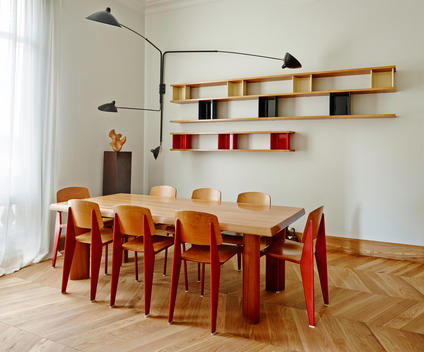 MA Apartment, Barcelona, Spain. Modern wood dining table and chairs with colourful shelves on wall.