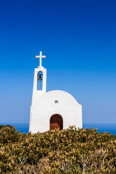 Small chapel on the cliff top outside of Elounda looking out on to the Aegean Sea, Crete, Greece.