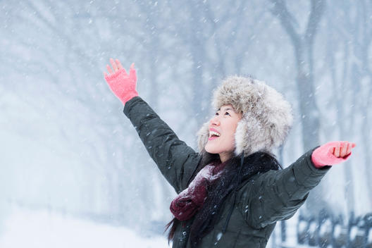 Asian woman cheering in snow