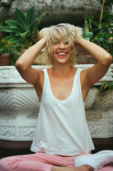Pretty blonde girl smiling, and messing up her hair.