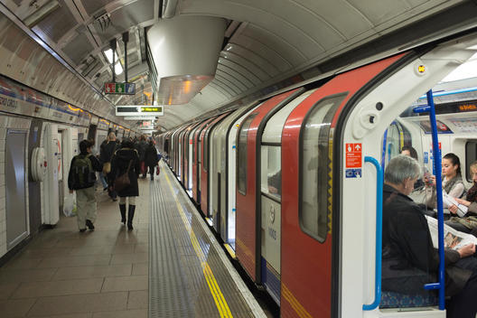 tube train in station and people walking on platform in the London Underground