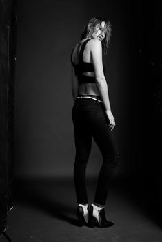Fashion model shot in black and white in studio with wet hair and black tank top.