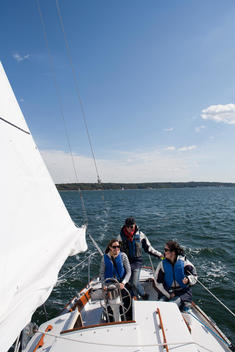 Three People Steering Sailboat