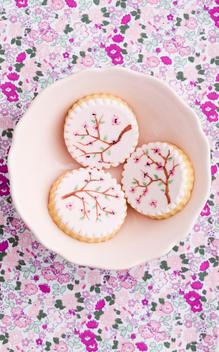 Painted pink sugar cookies in bowl, close up