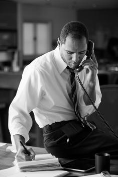 Mixed race businessman talking on telephone