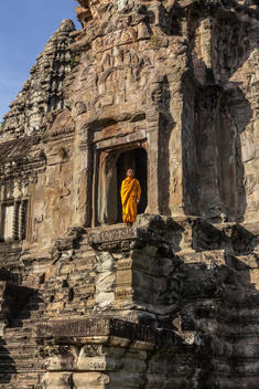 Young Buddhist monk standing at temple in Angkor Wat, Siem Reap, Cambodia