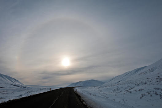 Sun with halo in pale winter landscape, Godafoss, North Iceland