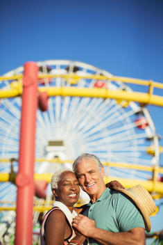 Portrait of happy senior couple hugging at amusement park
