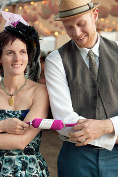 Man and woman in vintage attire with a party popper.