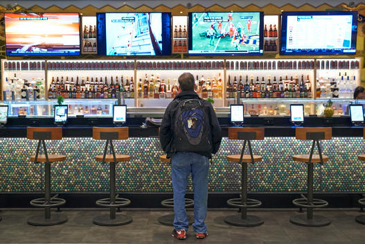 early morning view of multimedia bar at Newark airport with I pads and large TV screens