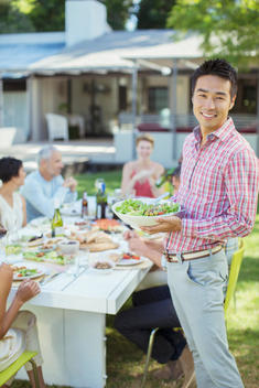 Man serving friends at table outdoors