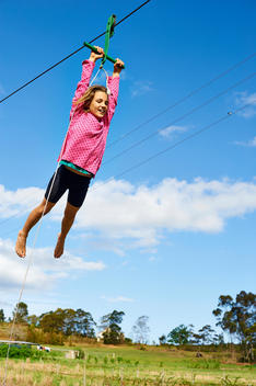 girl sliding on a hand swing and smiling
