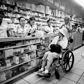 An Elderly American Women In A Wheel Chair Waits For Her Prescription In The Cotton Pharmacy In Algodones, Mexico.