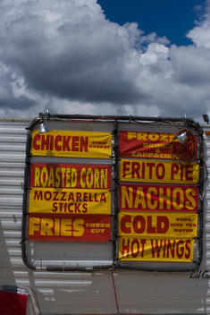 Food Truck Sign Against A Blue Sky And Clouds At A County Fair