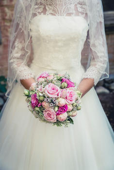 bride with the wedding bouquet, wedding dress with lace and veil