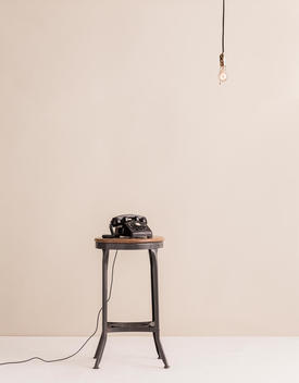 Telephone on stool and light bulb hanging
