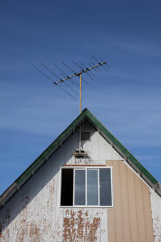 An Antenna Sits On Top Of The Roof Of A House.