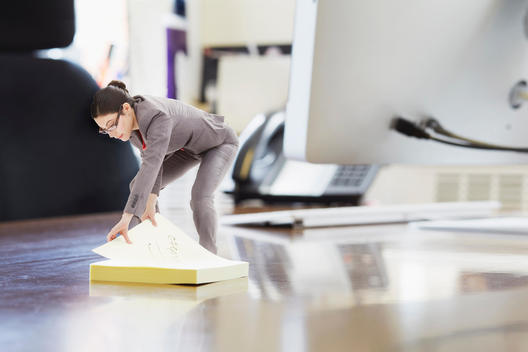 Businesswoman using large adhesive label on oversized desk