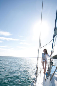 Woman Standing At Bow Of Sailing Boat