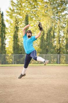 Girl (13-15) playing baseball