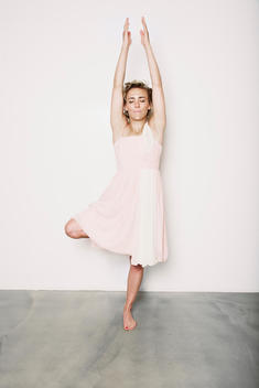 Young woman with cocktail dress practicing yoga