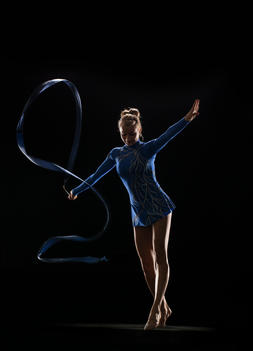 Athletic Olympic rhythmic gymnast performing with ribbon