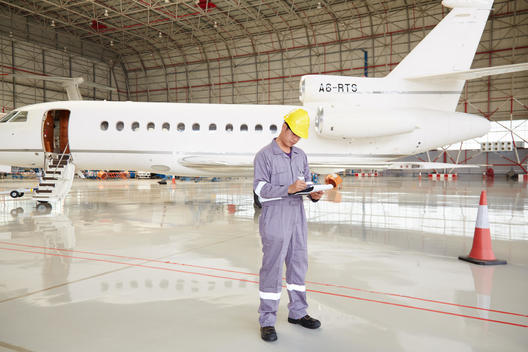 Engineer inspecting on plane in hanger