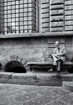 A man reads the newspaper in the street - (Candid urban street)