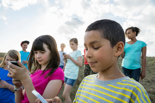 Children using mobile phones during field trip