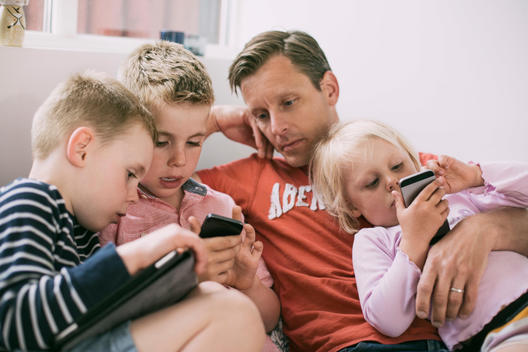 Father and children using technologies at home