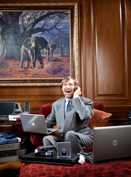 Dr. Henry Nicholas III, co-founder of Broadcom, philanthropist and billionaire, talks on his phone and works on a laptop in his lavish home