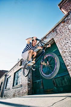 Caucasian man jumping on BMX bike