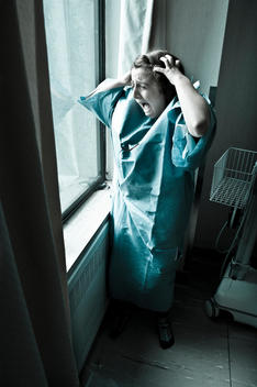 A Girl Screaming Near A Window To Get Out Of A Hospital Room.