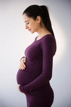 Pregnant Caucasian woman holding stomach