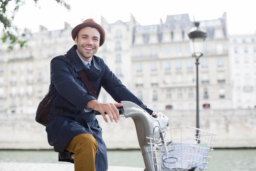 Businessman on bicycle along Seine River, Paris, France