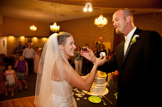 A bride\'s warning look to her groom as they prepare for the cake sharing tradition