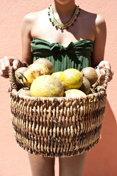 Woman Holding A Basket Of Coconuts
