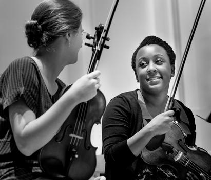 Students playing violin in college orchestra