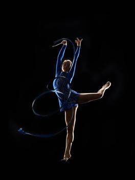 Athletic Olympic rhythmic gymnast performing with ribbon