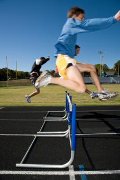 High School Athlete Jumping Hurdles
