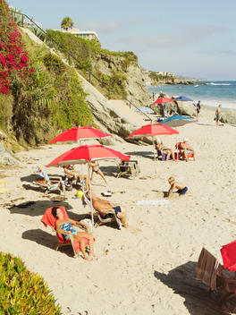 Beach goers take sunbath on Laguna beach California.