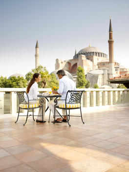 Man and woman having breakfast with mosque in background.