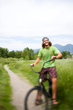 Portrait of young adult man on a cruiser bike outdoors