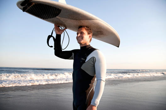 Surfer carrying surfboard on head