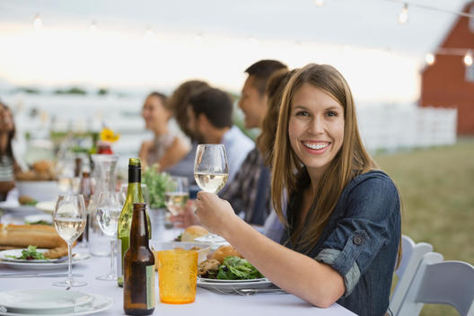 Portrait of smiling woman holding wineglass at dinner party