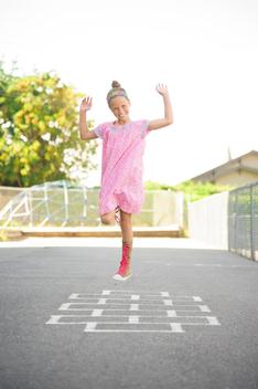 Girl (10-12) in pink dress jumping