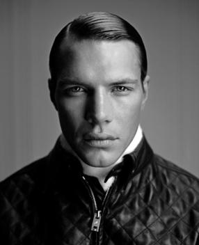 Close Up Of A Stylish Man With A Zip Down Jacket And Slicked Back Hair.