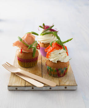 Variety of hearty cup cakes on wood board