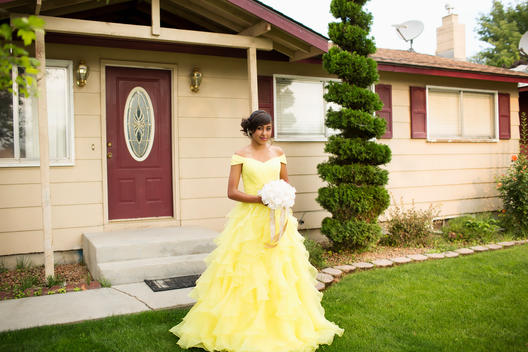 Hispanic girl wearing quinceanera dress in front lawn